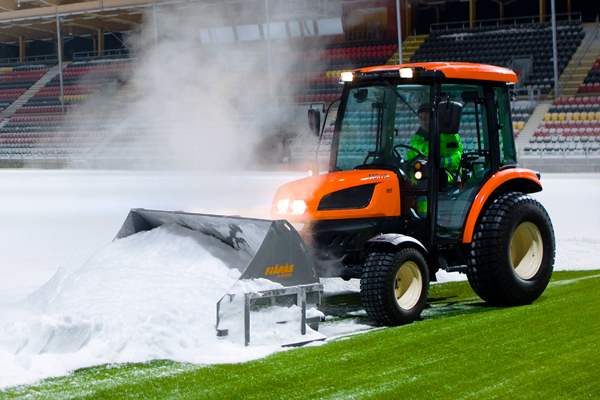 konstgräsplog på fotbollsplan som röjer snö