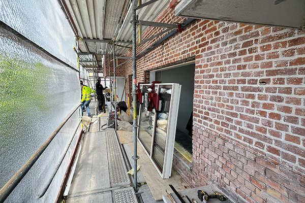 Upclimber elektrisk fönsterlyft används vid montering av stora fönster på byggställning